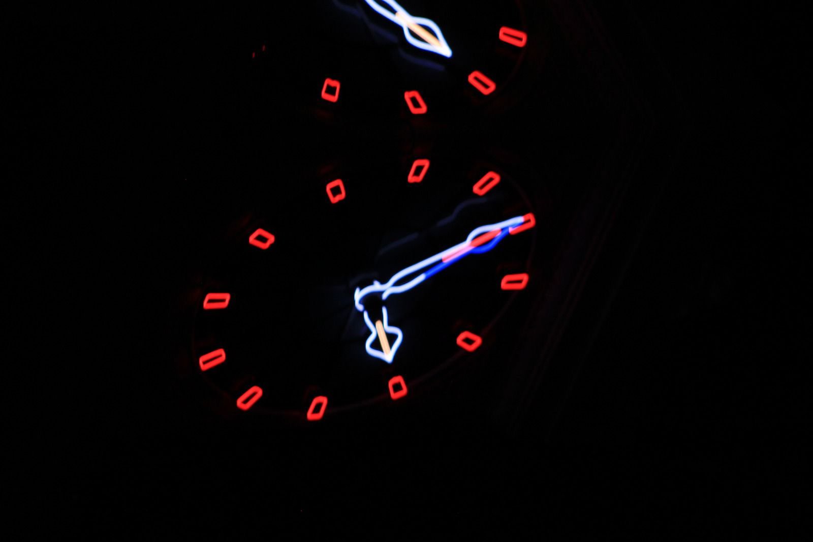 Two glowing clock faces with red markers emerging from darkness — Joe Passage