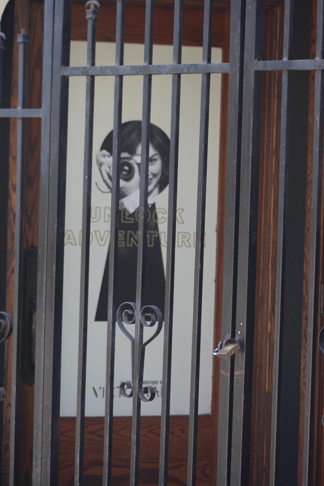 Woman with a camera seen behind a metal gate in Vancouver
