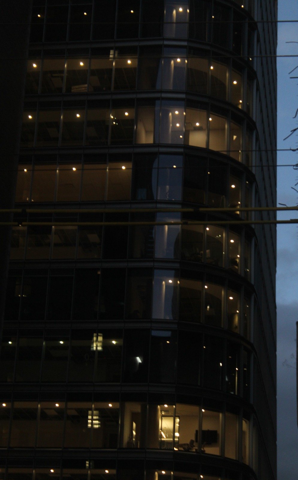 Illuminated windows in a dark glass building in Vancouver
